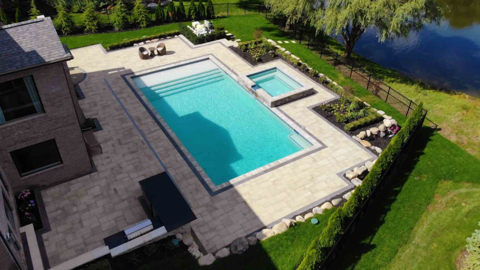 Michigan spa design, spillover spa design, spillover spa inspo, landscape design, michigan pool design, paving company in Michigan, inground pool, pool inspo, backyard pool, pavers, pavers near me, swim and spa, swimming pool design and install, backyard ideas, privacy fence ideas, backyard landscaping ideas, unilock, patio pavers near me, patio pavers Oakland twp, patio pavers Oakland County, paving near me, michigan top pavers, landscape design architect inground pool with raised spa spillover spa