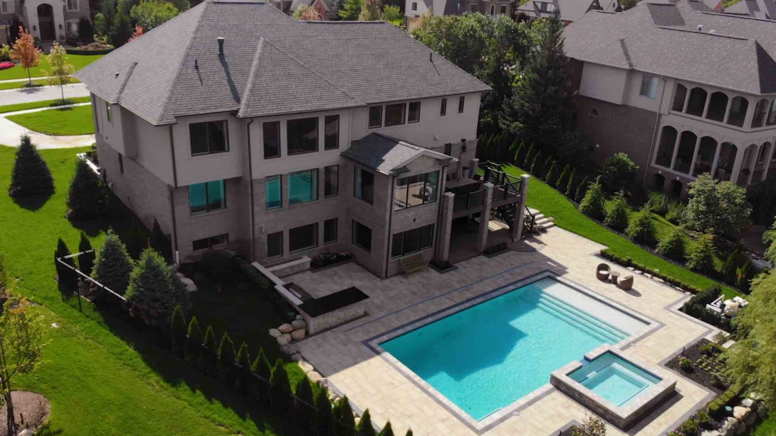 Michigan spa design, spillover spa design, spillover spa inspo, landscape design, michigan pool design, paving company in Michigan, inground pool, pool inspo, backyard pool, pavers, pavers near me, swim and spa, swimming pool design and install, backyard ideas, Oakland county landscaping, pool design near me inground pool with raised spa