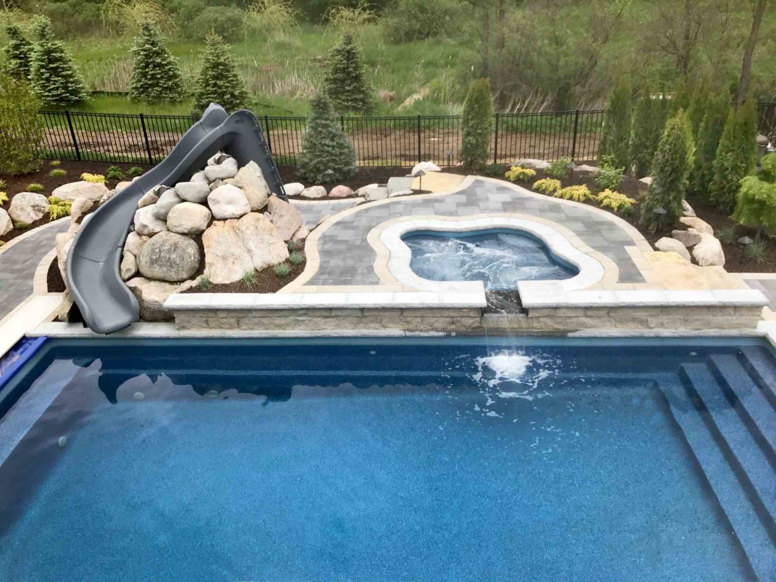 luxurious inground pool contractor in Northville, MI Rectangle fiberglass pool Pool and cascade spa michigan custom pools and spas backyard patio design oakland twp Custom inground pool pool and spa design Metro Detroit Metro Detroit pool and spa experts Custom pool design Metro Detroit Spa installation in Metro Detroit Metro Detroit outdoor spa design Residential pool design Metro Detroit