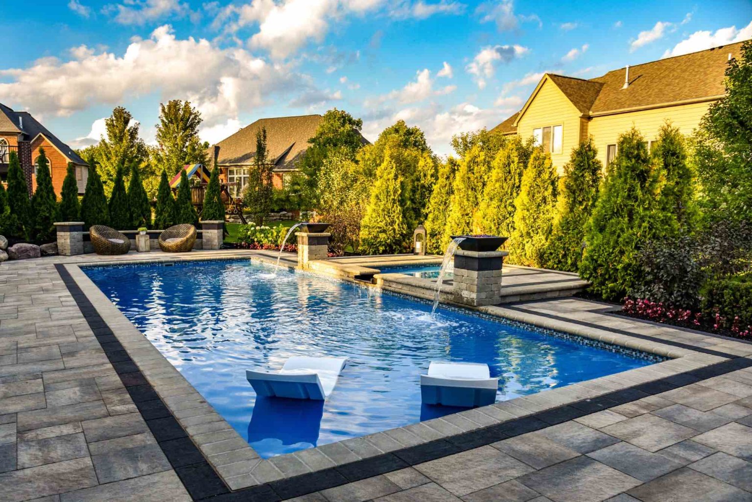Arborvitae privacy trees  fiberglass pool designers in Shelby Twp, Mi landscape design project in Shelby Township cascade fiberglass swimming pool design with a raised spillover spa  pool and spa design Metro Detroit Metro Detroit pool and spa experts Custom pool design Metro Detroit Spa installation in Metro Detroit Metro Detroit outdoor spa design Residential pool design Metro Detroit Metro Detroit luxury pool and spa