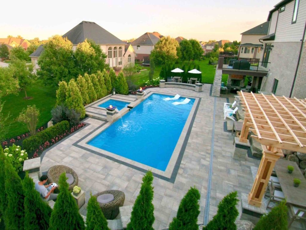 Arborvitae privacy trees  fiberglass pool designers in Shelby Twp, Mi landscape design project in Shelby Township cascade fiberglass swimming pool design with a raised spillover spa  Michigan Landscape Design Landscape Design Services in Michigan Professional Landscape Design Michigan Michigan Landscape Architects Best Landscape Designers in Michigan