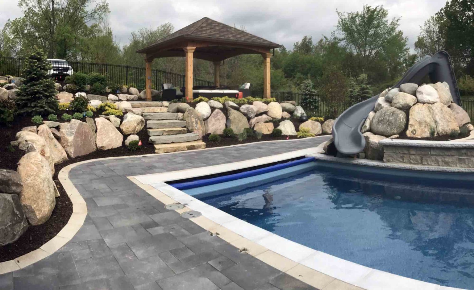 luxurious inground pool contractor in Northville, MI Rectangle fiberglass pool cedar gazebo se michigan Swim spas in southeast michigan Outdoor living space with custom pool and spa shade structures in Michigan Michigan shade solutions Outdoor shade Michigan Shade canopy Michigan pool with slide