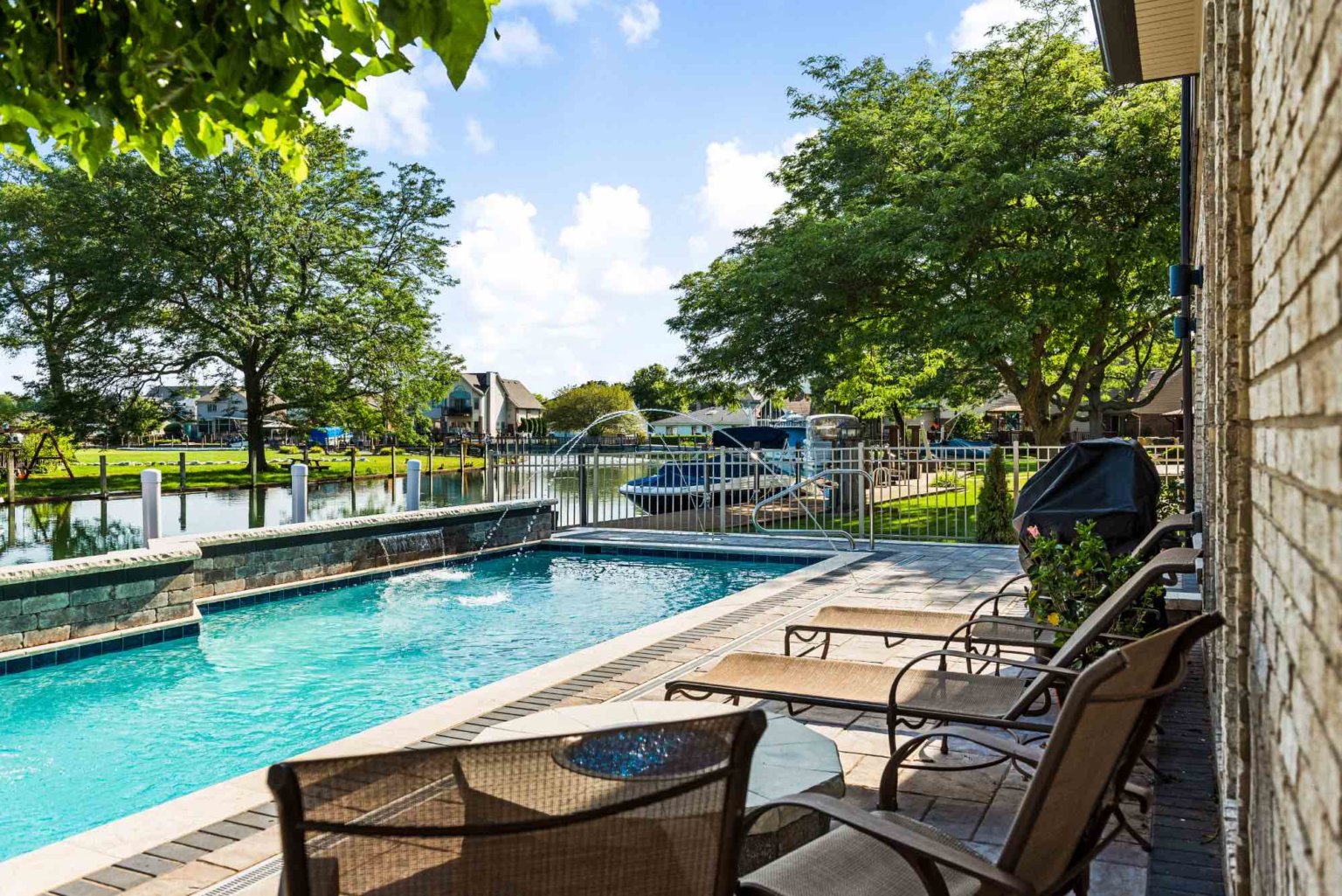 luxury custom gunite swimming pool with jet fountains and sheet fountains Unilock pool deck design Michigan Landscape Design Landscape Design Services in Michigan Professional Landscape Design Michigan Michigan Landscape Architects Best Landscape Designers in Michigan Michigan Residential Landscape Design Custom Landscape Design Michigan Michigan Garden Design Landscape Planning Michigan Landscape Installation Michigan Custom inground pools