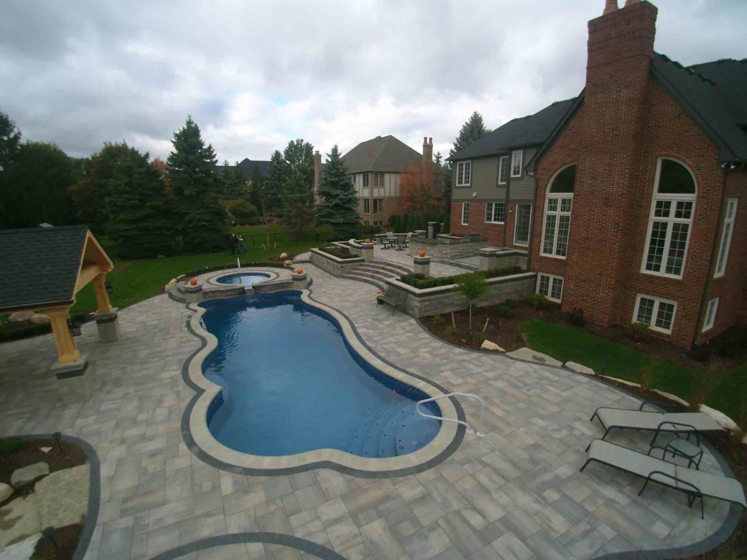 terrace paver patio & luxury pool Oakland twp michigan outdoor grilling station builders michigan Gunite Pool Construction Custom Gunite Pool Designs Gunite Pool Installation Gunite Pool vs. Vinyl Pool Gunite Pool Benefits Gunite Pool Cost Gunite Pool Maintenance