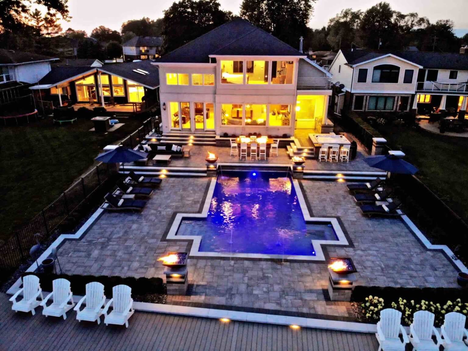 evening view of lakeside pool and patio Gunite Pool Construction Custom Gunite Pool Designs Gunite Pool Installation Gunite Pool vs. Vinyl Pool Gunite Pool Benefits Gunite Pool Cost Gunite Pool Maintenance pool and spa design Metro Detroit Metro Detroit pool and spa experts Custom pool design Metro Detroit Spa installation in Metro Detroit Metro Detroit outdoor spa design Residential pool design Metro Detroit Metro Detroit luxury pool and spa Pool and spa renovation Metro Detroit Metro Detroit backyard pool design Metro Detroit pool and spa builders Metro Detroit pool and spa contractors