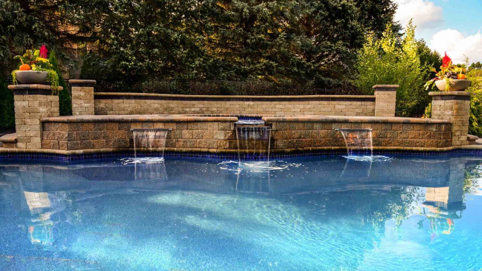 pool level view of hot tub spillover into pool Custom inground pools Backyard pool ideas detroit pool and spa design Metro Detroit Metro Detroit pool and spa experts Custom pool design Metro Detroit Spa installation in Metro Detroit Metro Detroit outdoor spa design Residential pool design Metro Detroit Metro Detroit luxury pool and spa