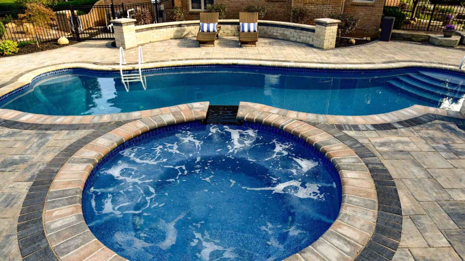 Hot tub with spillover into pool fiberglass pool and spillover spa in Washington Twp, Michigan Michigan Pavers Paver Installation Michigan Paver Contractors in Michigan Best Pavers in Michigan Michigan Patio Pavers Driveway Pavers Michigan Walkway Pavers Michigan Michigan Paver Stones Custom Pavers Michigan Michigan Paver Design
