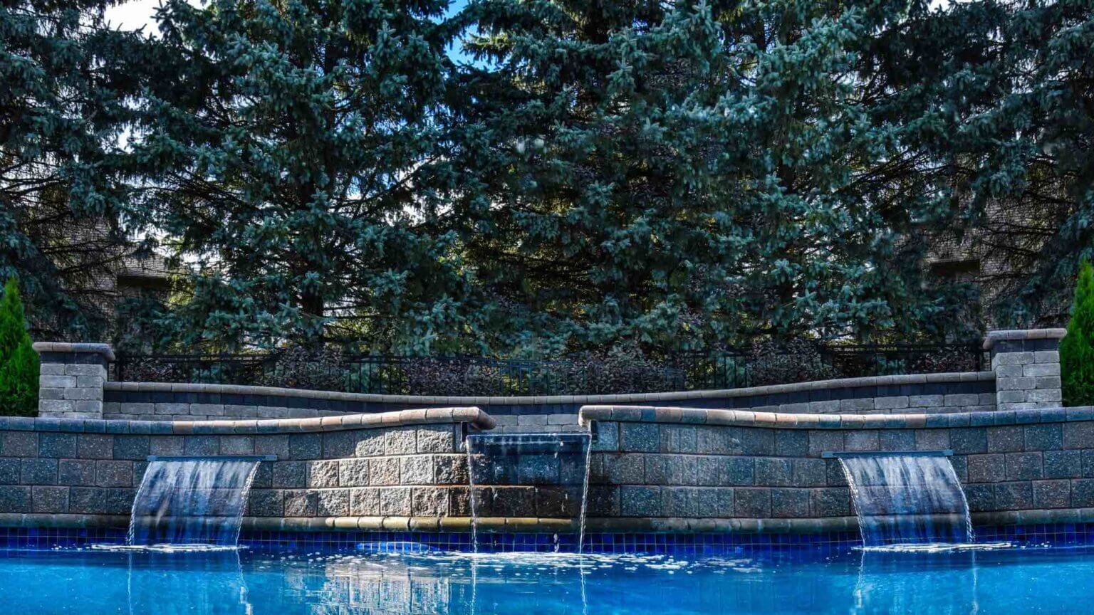 pool level view of hot tub spillover into pool privacy plantings