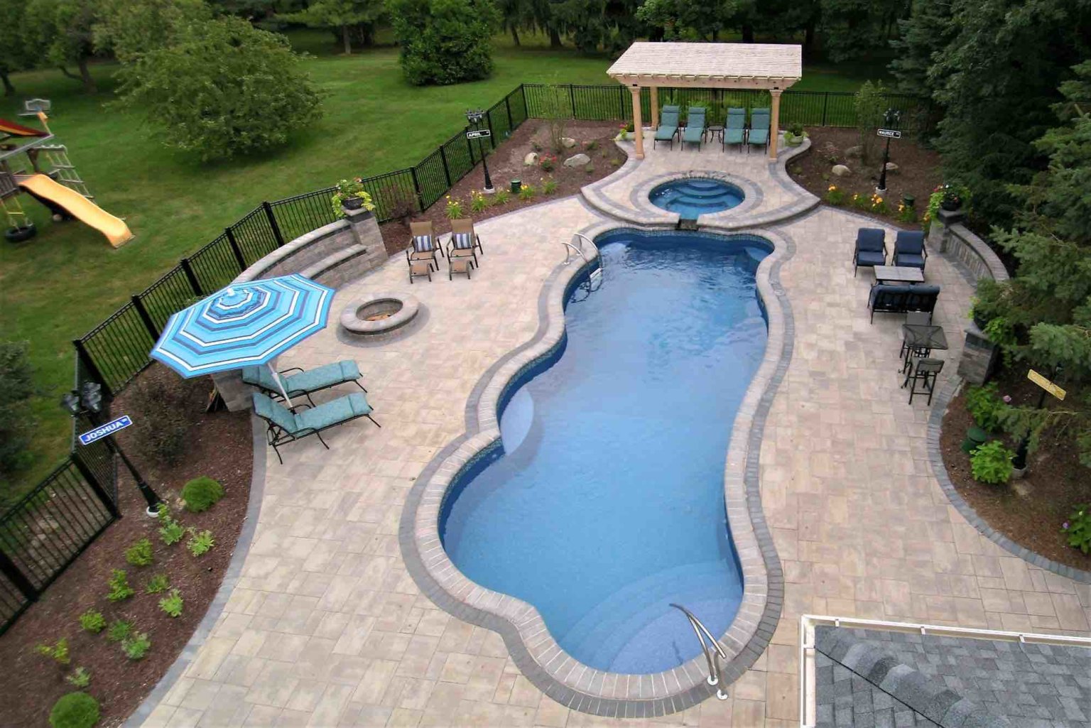 aerial view of pool, hot tube, fire pit and poolside lounge freeform pool builders se michigan Custom inground pools Backyard pool ideas detroit pool and spa design Metro Detroit Metro Detroit pool and spa experts Custom pool design Metro Detroit Spa installation in Metro Detroit freeform fiberglass pool & spillover spa in Clinton Twp MI