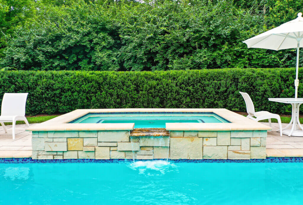 Michigan spa design, spillover spa design, spillover spa inspo, landscape design, michigan pool design, paving company in Michigan, inground pool, pool inspo, backyard pool, pavers, pavers near me, swim and spa, swimming pool design and install, backyard ideas, privacy fence ideas, backyard landscaping ideas, unilock brick paving in Bloomfield