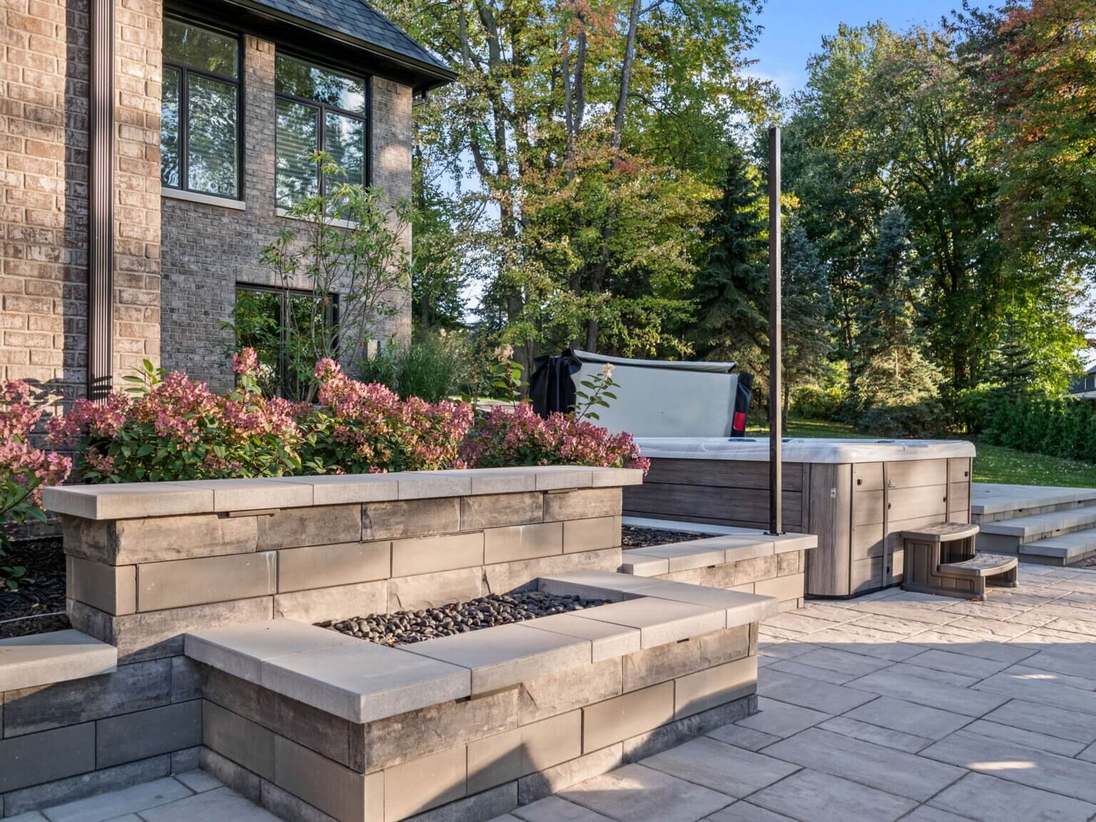Unilock paving stone Unilock retaining walls Unilock coping  Michigan fieldstone boulders Limestone outcropping  brick pavers in Washington, MI front and backyard brick paver services front paver entrance paved backyard patio built-in grilling station custom waterfall feature
